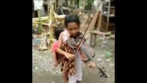 Viral, Seorang Gadis Gendong Adiknya Sambil Bermain Biola
