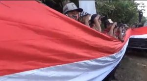 Bendera Raksasa Ukuran 3.000 Meter Dibentangkan di Pinggir Jalan Raya